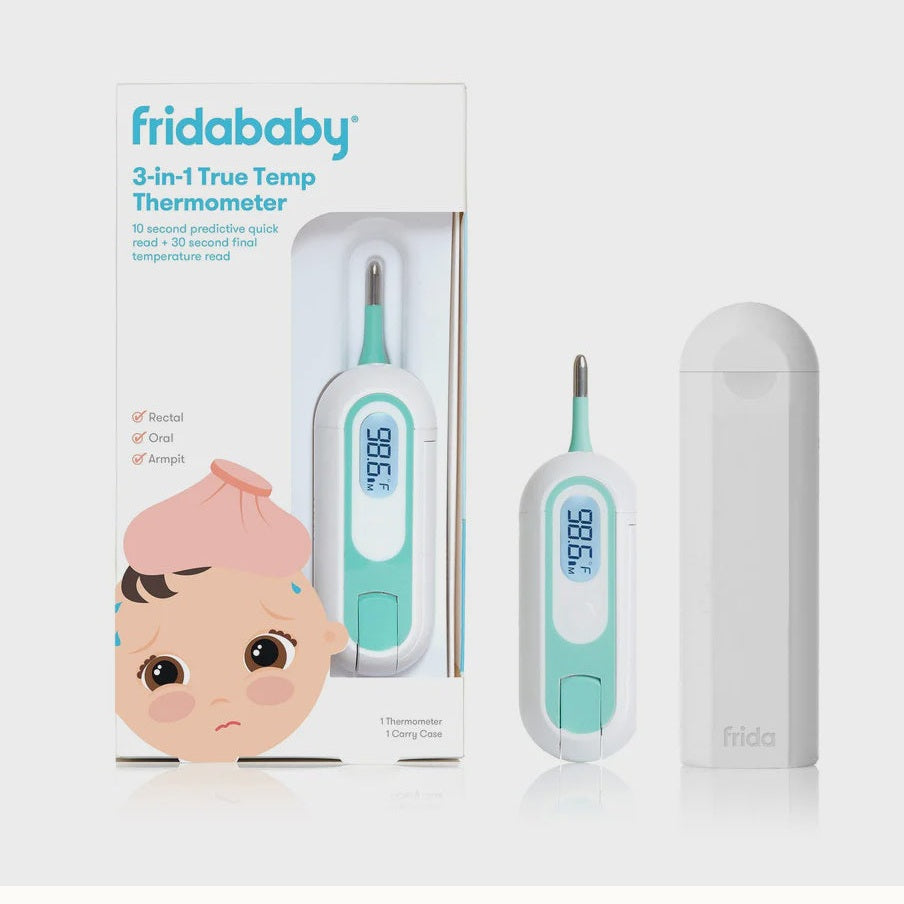 Commercial product photograph by Fridababy of the 3-in-1 True Temp Thermometer kit featuring the brand logo on a sleek white carry case, a digital display reading 98.6 degrees with teal accents, and retail packaging depicting a cartoon baby with a pink ice pack