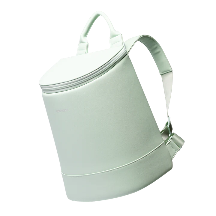 Digital product photograph of a Corkcicle mint green insulated cooler backpack in a studio setting featuring a matte seafoam finish, a circular zippered lid, and adjustable padded straps