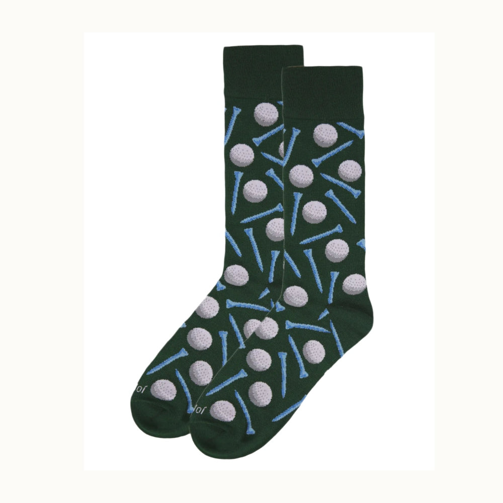 Product photography of a pair of dark forest green crew socks featuring a repeating pattern of dimpled light grey golf balls and vibrant blue tees against a white background