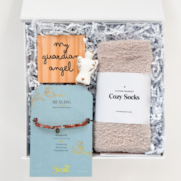 Gift set with 'my guardian angel' card, bracelet, and cozy socks in a box.