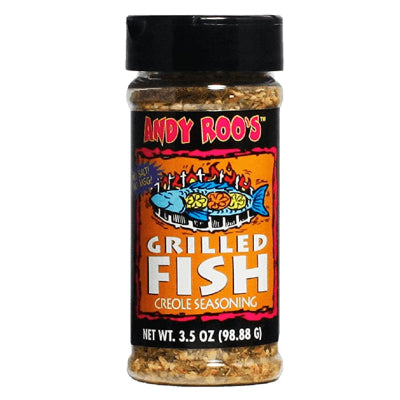 Digital photograph of an Andy Roo's Grilled Fish Creole Seasoning spice jar on a white background featuring a blue fish illustration with yellow citrus slices over bright orange grill flames