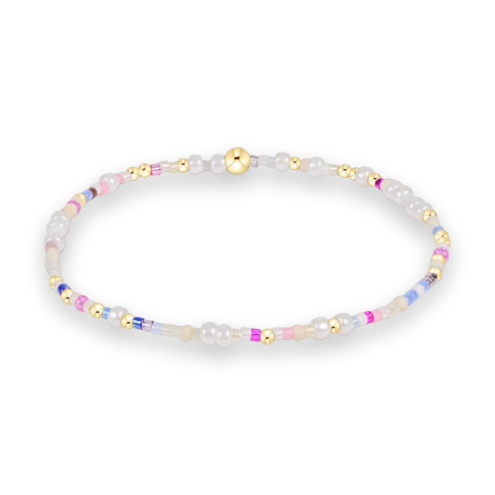 Handcrafted beaded bracelet on a white studio background featuring iridescent white pearls, vibrant pastel pink and lavender accents, and a central polished gold sphere bead
