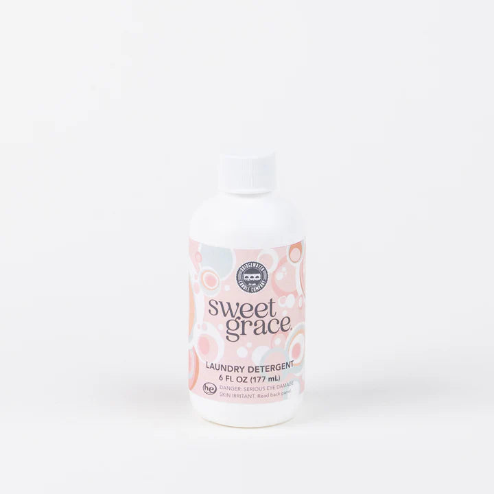 Product photograph of Bridgewater Candle Company Sweet Grace laundry detergent bottle on a white studio background with a pink and white decorative circular label and a white ribbed screw cap