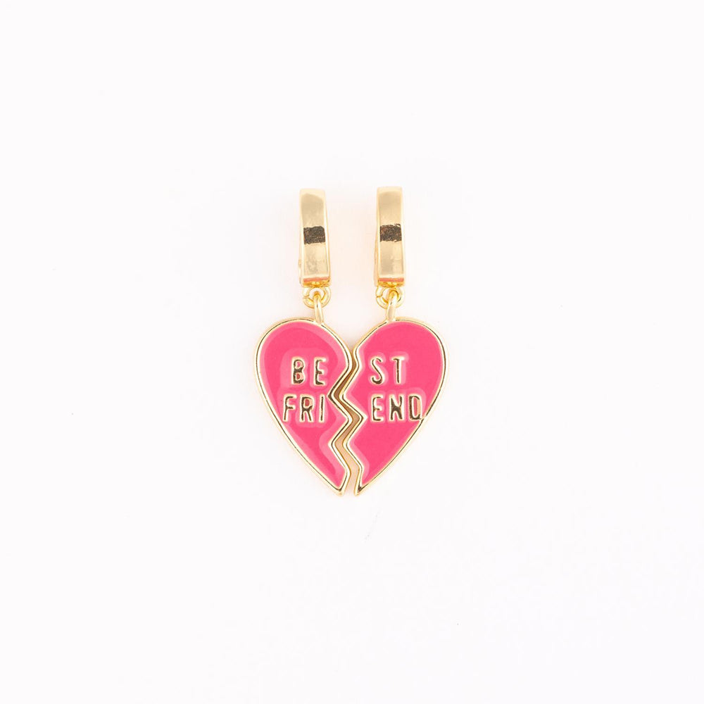 Gold-plated and pink enamel charms featuring two interlocking heart halves with the words BE ST FRI END engraved in gold against a plain white studio background