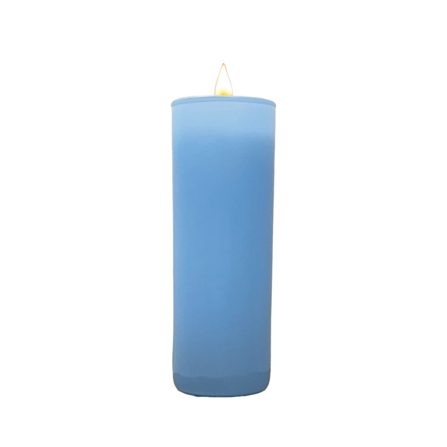 Photograph of a tall light blue pillar candle centered against a white background featuring a small glowing yellow flame and a smooth cylindrical wax body