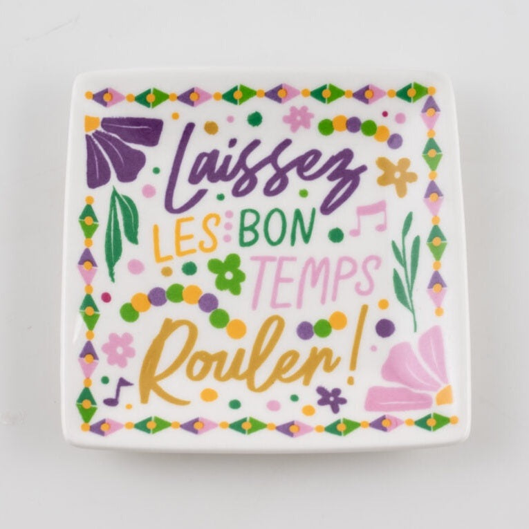 Ceramic trinket tray featuring the New Orleans Mardi Gras slogan Laissez les bon temps rouler with colorful purple beads, gold floral patterns, and music notes