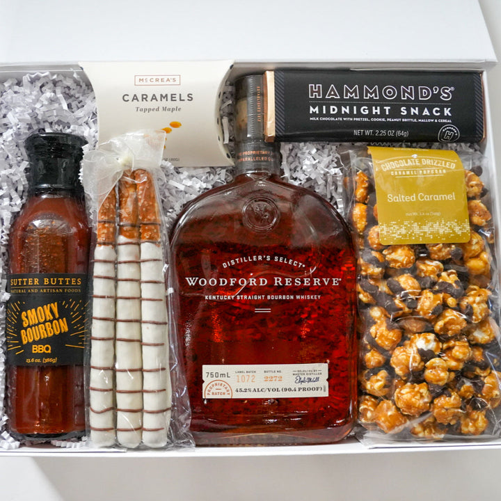 Gift set with Woodford Reserve bourbon, popcorn, and other snacks in a box labeled &