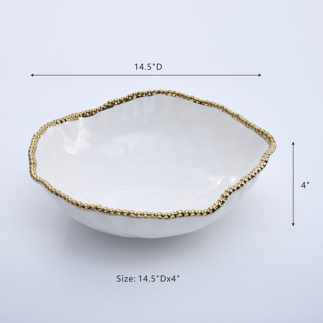 Ceramic glossy white decorative bowl in a studio setting featuring an organic irregular wavy edge and a textured metallic gold beaded rim