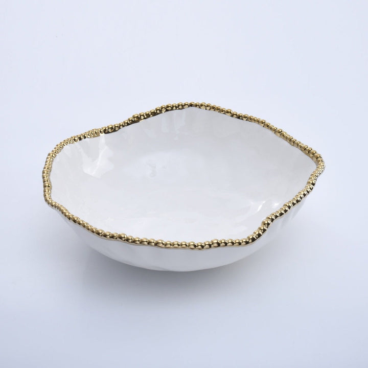 Ceramic white decorative bowl with an organic wavy rim and a metallic gold beaded edge positioned on a plain neutral surface