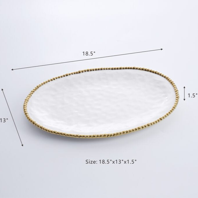 Ceramic oval serving platter shown on a white background featuring a textured hammered white surface, an elegant gold-beaded rim, and dimension markings of 18.5 by 13 inches