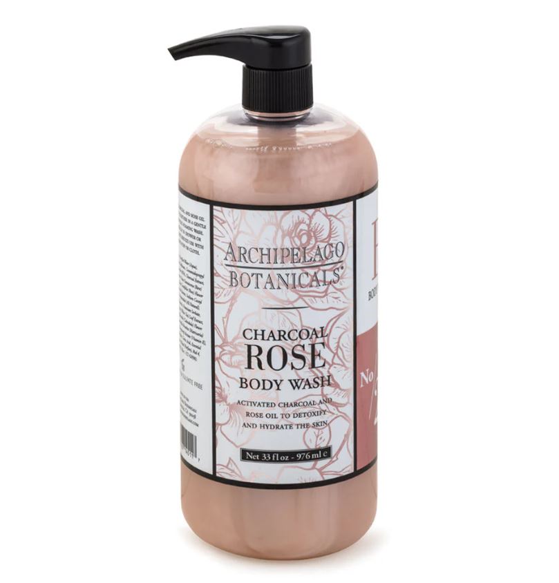 Product photograph of Archipelago Botanicals Charcoal Rose Body Wash featuring a large pump bottle filled with dusty rose liquid and a white label highlighting intricate floral sketches and a black dispenser pump against a white background