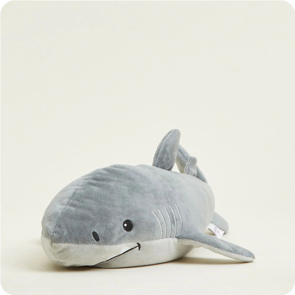 Plush stuffed animal of a friendly grey shark on a cream studio background featuring white embroidered gills, a tiny stitched smile, and a soft white underbelly