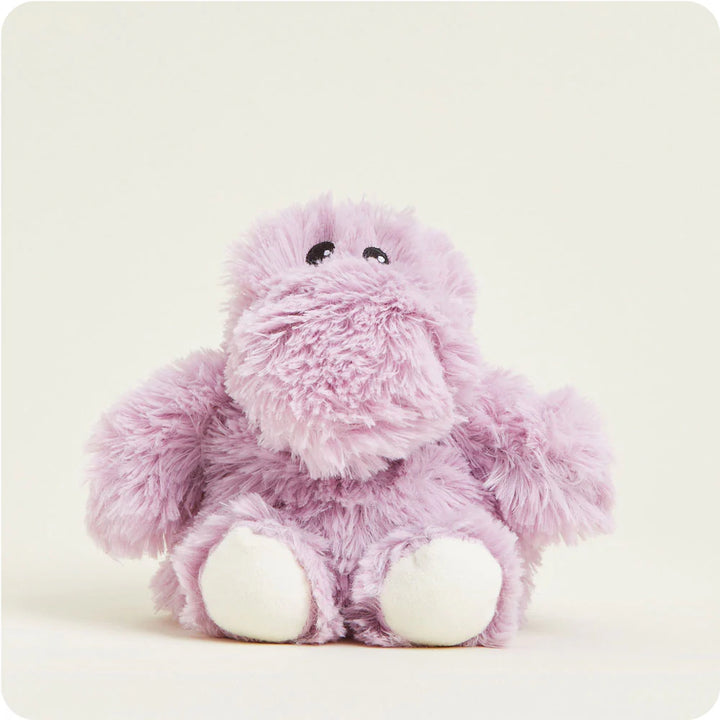 Stuffed animal by Jellycat featuring a lilac hippopotamus sitting on a plain off-white background with shaggy purple fur, tiny black beaded eyes, and cream-colored soles on its feet