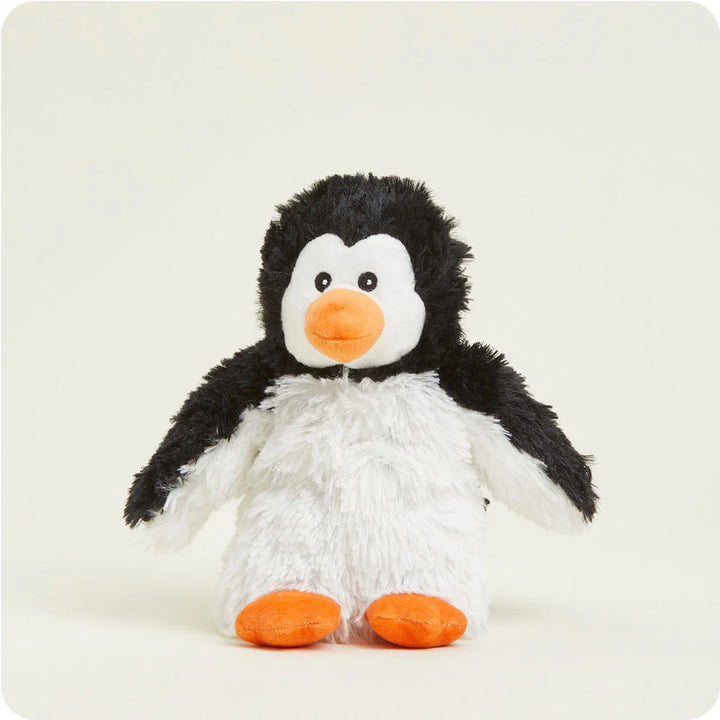 Plush toy by Jellycat of a Peanut Penguin standing on a neutral studio background featuring shaggy black and white fur, small black eyes, and vibrant orange feet