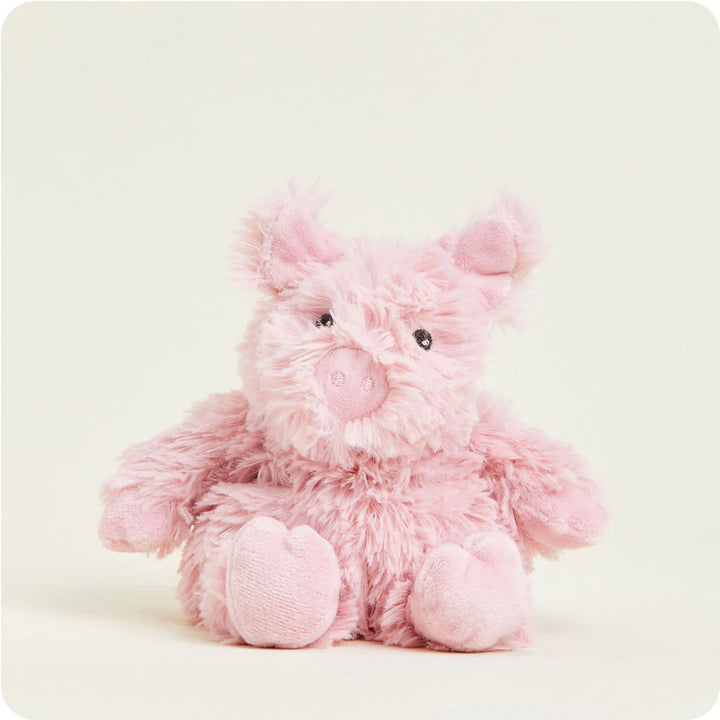 Jellycat plush toy of a pink pig in a studio setting with shaggy textured fur, small black bead eyes, and soft suede-like trotters