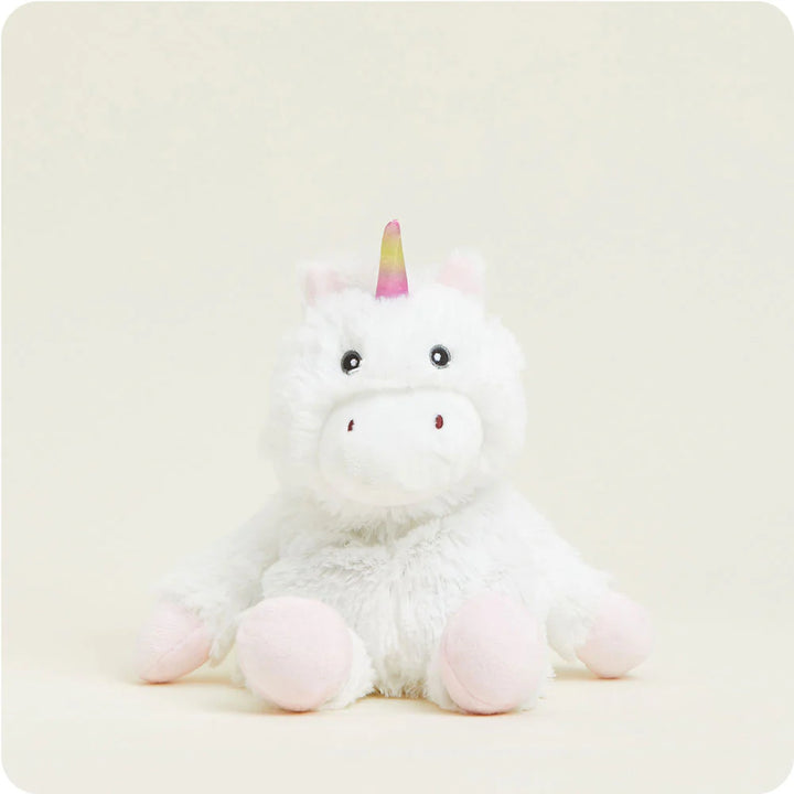 Plush stuffed toy of a white unicorn sitting against a plain cream background featuring a shimmering pink and yellow gradient horn, soft pink hooves, and black bead eyes