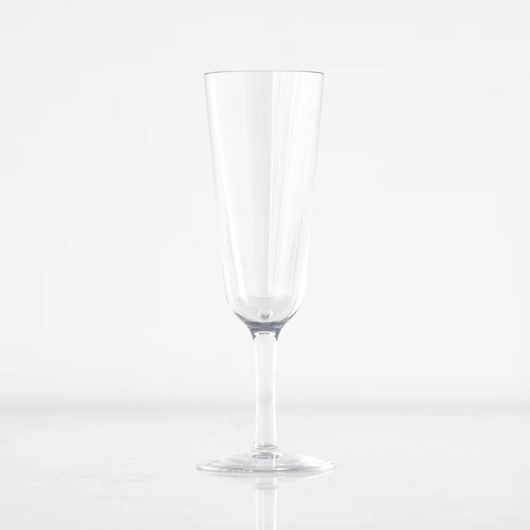 Product photograph of a clear glass champagne flute centered against a minimalist white background featuring a tall tapered bowl a slender stem and subtle vertical light reflections