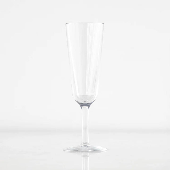 Product photograph of a clear glass champagne flute centered against a minimalist white background featuring a tall tapered bowl a slender stem and subtle vertical light reflections