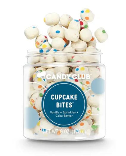 Commercial product photography for Candy Club featuring a clear plastic jar overflowing with vanilla cake batter cupcake bites adorned with colorful rainbow sprinkles and several pieces floating in the air against a white background