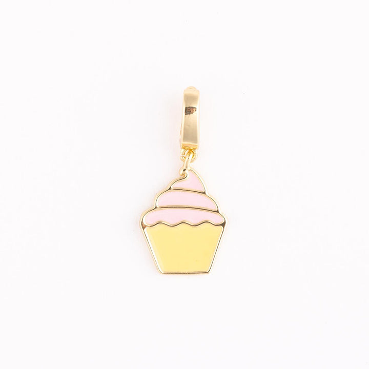 Enamel and gold-tone metal jewelry charm of a cupcake centered on a plain white background featuring tiered pink enamel frosting, a pale yellow fluted base, and a polished gold hanging loop