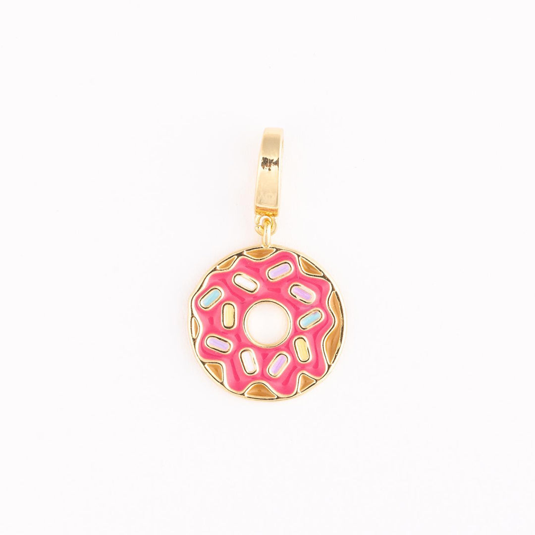 Enamel and gold-toned jewelry charm of a donut on a white background featuring vibrant pink frosting, pastel-colored sprinkles, and a scalloped golden edge