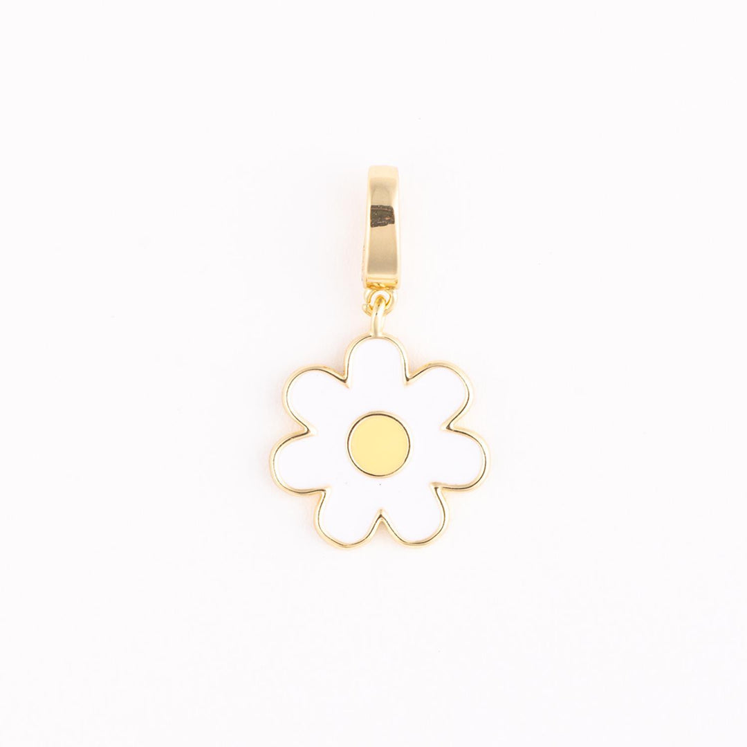 Gold-plated enamel jewelry charm featuring a stylized white daisy flower with six rounded petals and a vibrant yellow core suspended from a polished gold bail against a minimalist white backdrop