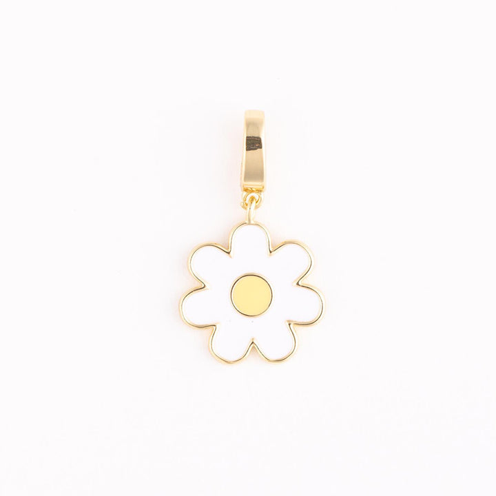Gold-plated enamel jewelry charm featuring a stylized white daisy flower with six rounded petals and a vibrant yellow core suspended from a polished gold bail against a minimalist white backdrop