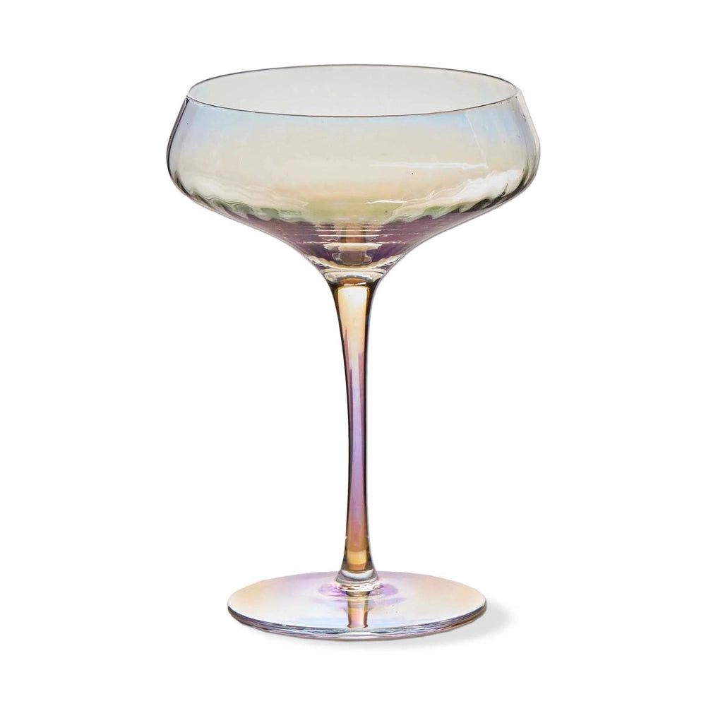 Iridescent glass champagne coupe isolated on a white background featuring a delicate ribbed texture at the base of the bowl and a slender stem reflecting a shimmering spectrum of pink and gold pearlescent hues