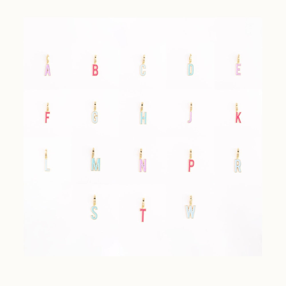 Gold and enamel jewelry collection of alphabet letter charms displayed on a clean white background featuring vibrant pink and baby blue enamel fills with polished gold-trimmed outlines and small attachment loops