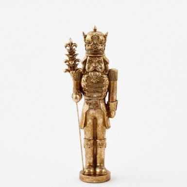 Gold-finished resin sculpture of a regal nutcracker king standing against a plain white background featuring an ornate filigree crown, a fleur-de-lis scepter, and a weathered metallic texture