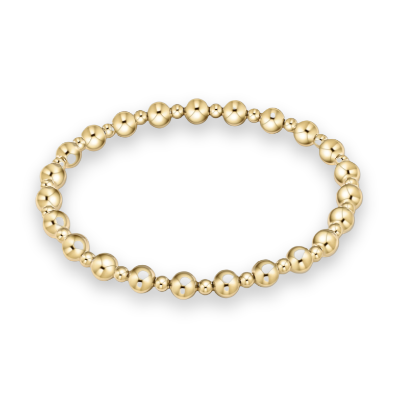 Studio product photograph of a polished gold beaded bracelet centered on a white background featuring alternating large and small spherical beads with a brilliant high-shine reflective finish