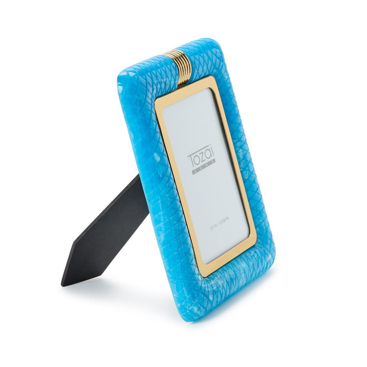 Resin Tozai Home turquoise picture frame featuring a textured snakeskin pattern, gold metallic inner border, and a decorative ribbed gold clasp with the brand logo on a white backdrop
