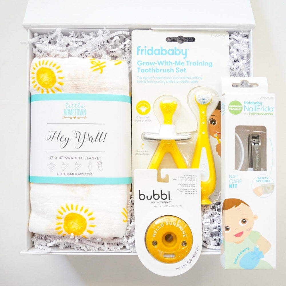 Baby product set including a toothbrush, teether, and other items in packaging on a white background