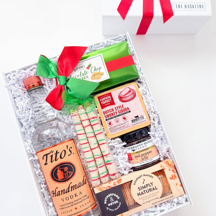 A curated gift box set on a white background, featuring a bottle of Tito&
