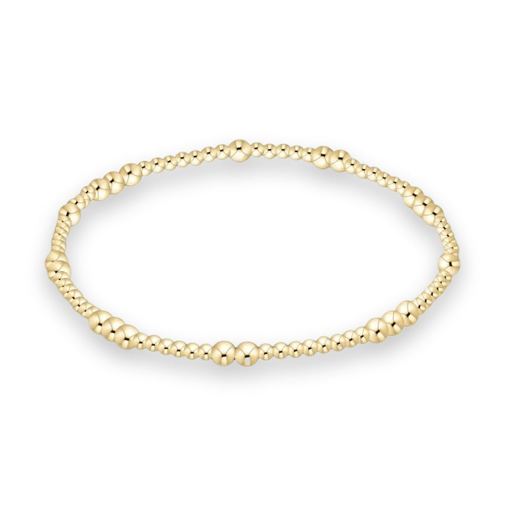 Yellow gold beaded bracelet featuring graduated spherical beads with a high-polish reflective finish centered on a minimalist white background
