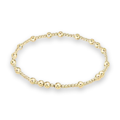 Gold-filled jewelry beaded bracelet featuring alternating sizes of high-polish yellow spheres and a seamless elastic design displayed against a clean white background