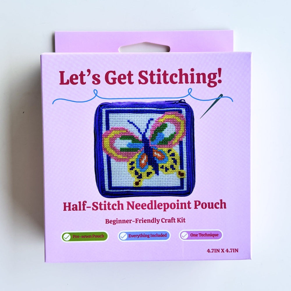 A boxed craft kit labeled "Let's Get Stitching!" and "Half-Stitch Needlepoint Pouch" on a plain white background. The package is light purple/lilac with a butterfly needlepoint example shown on the front.