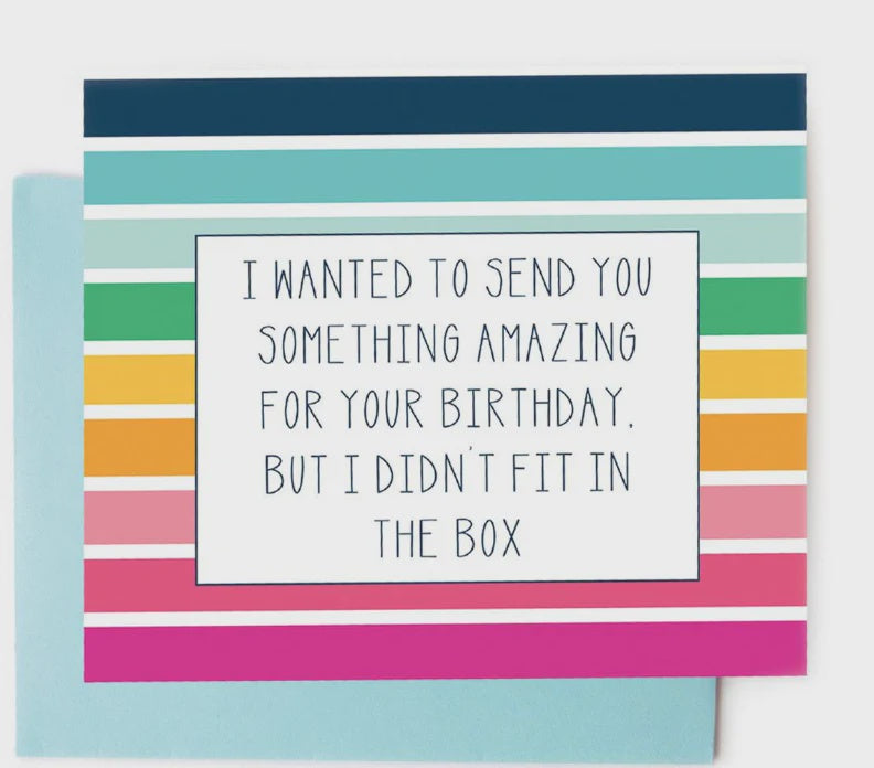 Greeting card design featuring a humorous birthday message centered in a white frame on a background of vibrant multi-colored horizontal stripes in shades of navy, teal, and hot pink, resting atop a light blue envelope