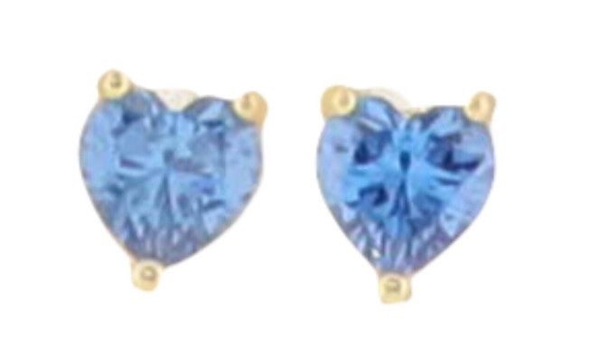 Jewelry photograph of heart-shaped stud earrings featuring vibrant faceted blue gemstones and yellow gold three-prong settings centered on a white background