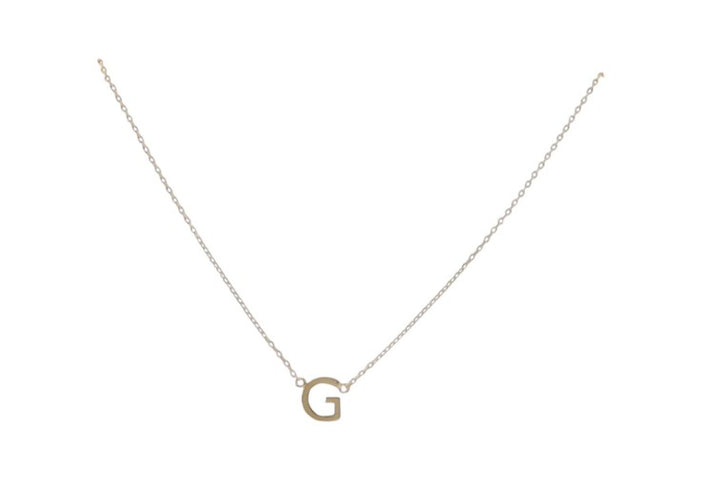 Gold jewelry necklace featuring a polished capital letter G pendant suspended from a delicate cable chain on a minimalist white background with a warm metallic sheen and fine interlocking links