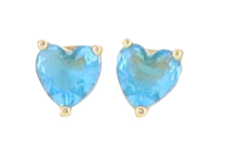 Gold and blue gemstone stud earrings featuring a pair of heart-shaped faceted cerulean stones secured in three-prong yellow gold settings against a plain white background
