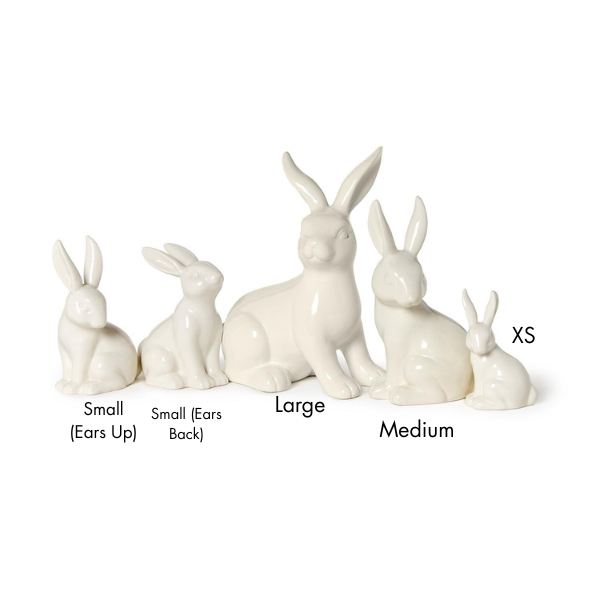 Ceramic rabbit figurines in a glossy cream glaze are displayed on a white background, featuring five distinct sizes labeled from extra-small to large with varied ear positions including alert upright and swept back