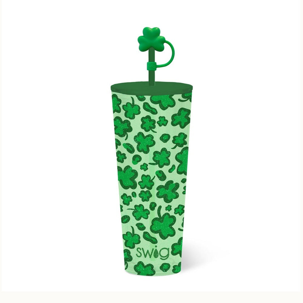 Commercial product photograph of a Swig Life tumbler featuring a shimmering green shamrock and leopard print pattern, a matching green lid, and a decorative clover-shaped straw topper against a white background