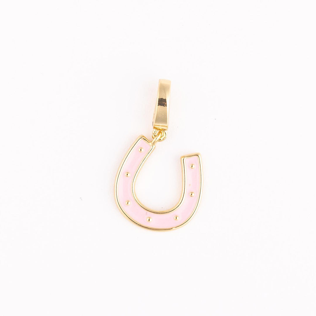 Gold-plated and enamel jewelry charm featuring a pastel pink horseshoe centered on a white background with seven small gold stud accents and a polished rectangular bail