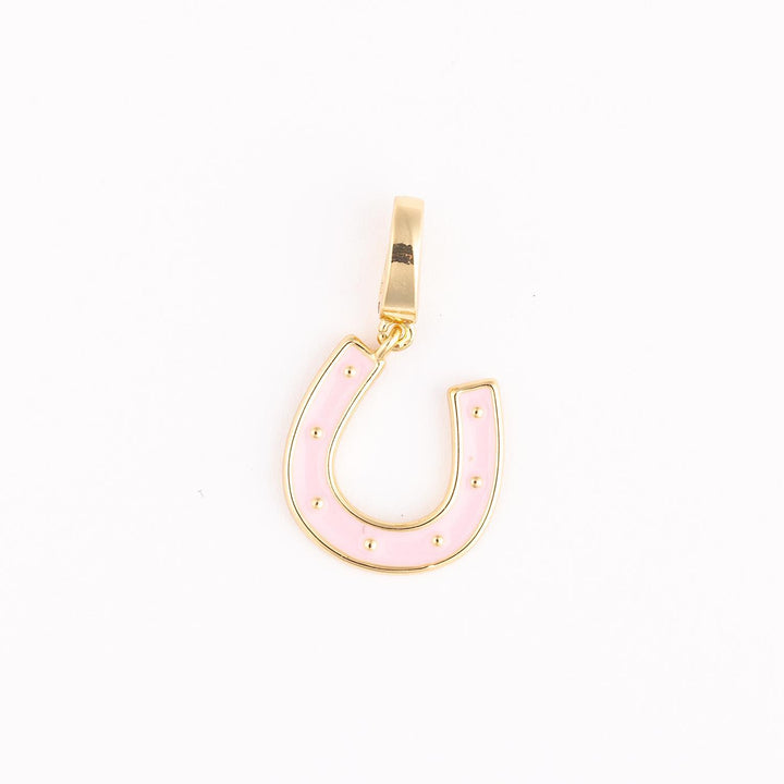 Gold-plated and enamel jewelry charm featuring a pastel pink horseshoe centered on a white background with seven small gold stud accents and a polished rectangular bail