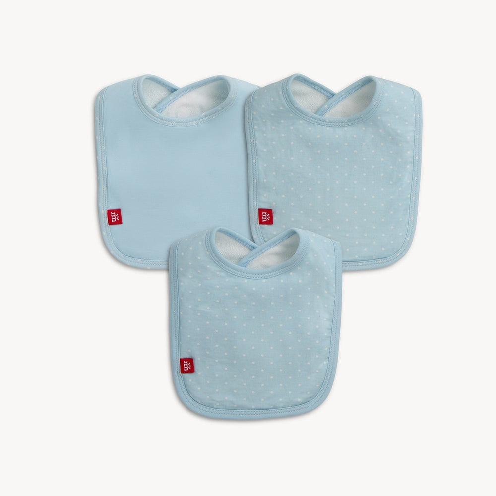 Product photograph of Mothercare baby bibs showcasing three light blue infant bibs on a white background including two with white polka dots and one solid blue design featuring small red logo tags