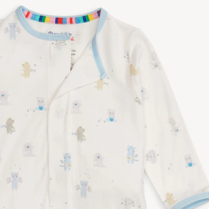 Cotton baby sleepsuit featuring a whimsical all-over print of musical animals including a blue cat playing guitar and a bear with maracas, detailed with light blue neckline trim and a vibrant rainbow-striped inner collar tape