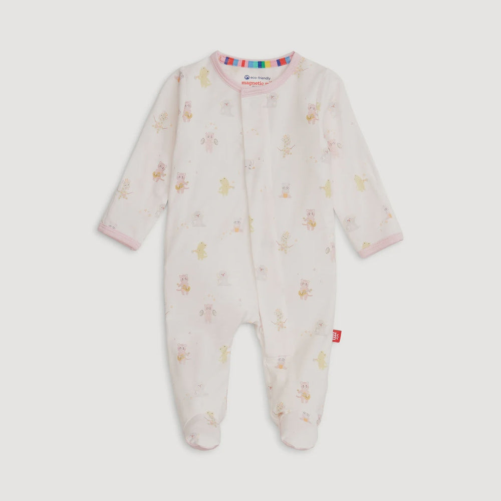 Product photograph of a Magnetic Me footed sleeper on a solid gray background featuring a whimsical animal band print, soft pink piping, and a colorful rainbow-striped interior neckline