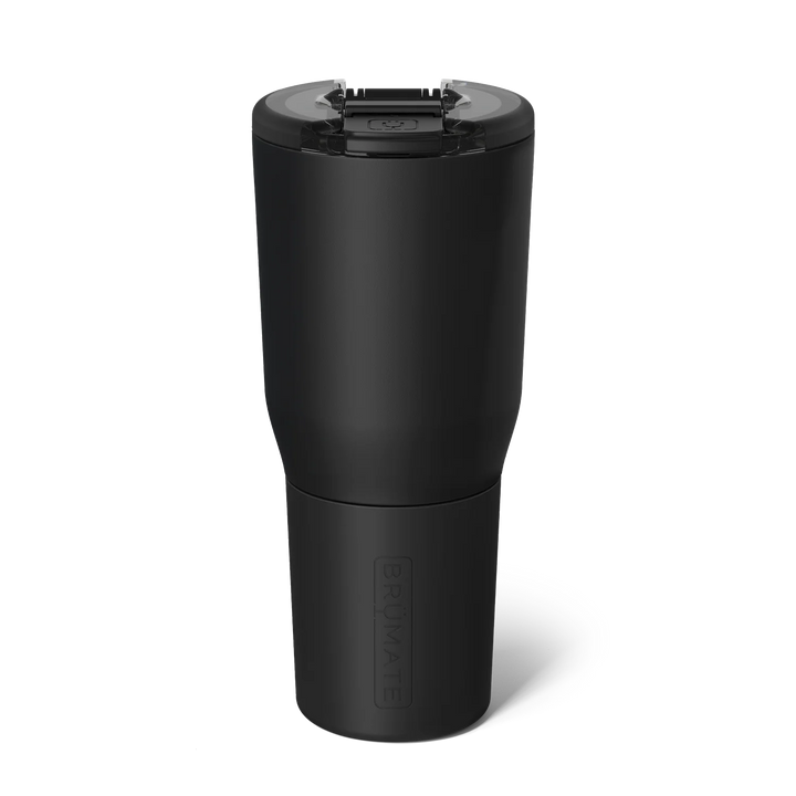 Product photograph by BrüMate of a matte black insulated tumbler against a white background featuring a clear leak-proof lid with a black flip-top latch and a vertically embossed logo on the tapered base