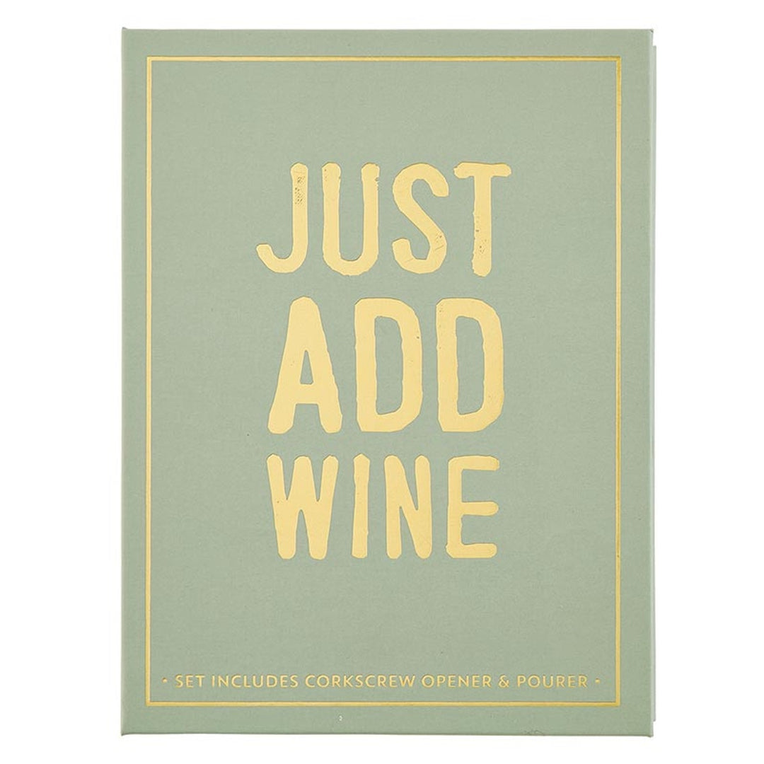 Graphic design on a sage green book-shaped gift box featuring bold gold foil typography reading JUST ADD WINE centered within a thin gold border with distressed lettering and subtext listing included wine accessories